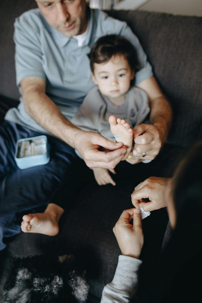 A family tending to a child's foot injury with first aid at home.